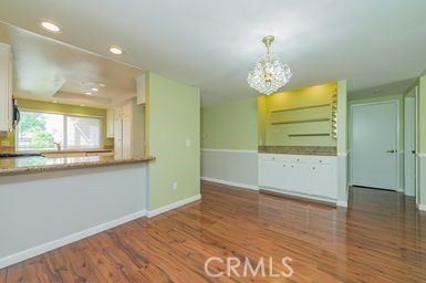 14 Featherwood Irvine, CA 92612 - Photo 7 of 32 a view of an empty room with wooden floor and a window
