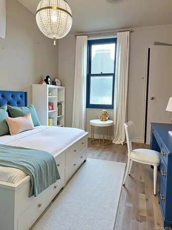 a bedroom with a bed and a chandelier