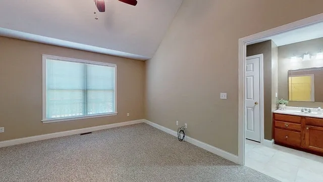 an empty room with a window and bathroom