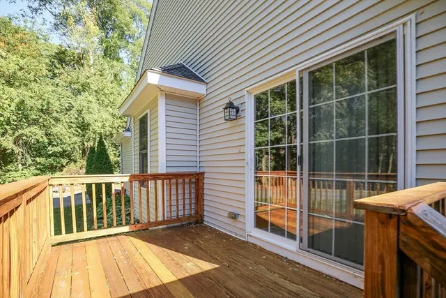 a view of a house with backyard and wooden deck
