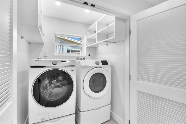 a view of a house with a yard and a large tree