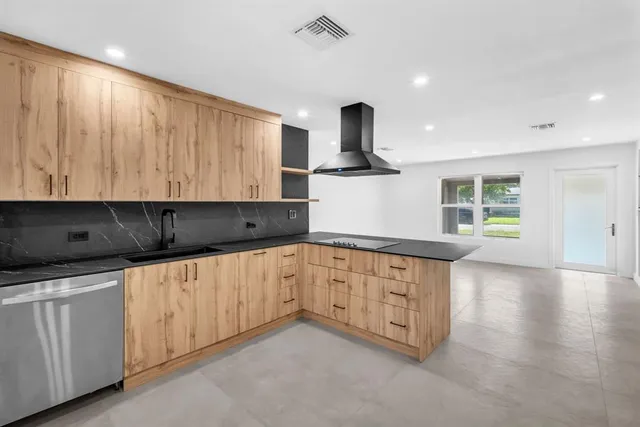 a kitchen with granite countertop white cabinets and window