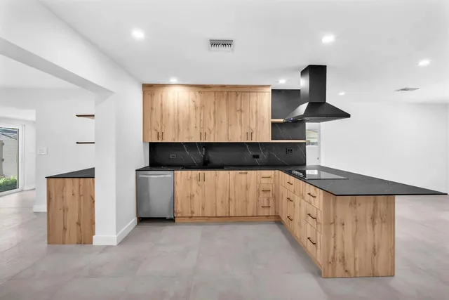 a kitchen with granite countertop white cabinets and stainless steel appliances