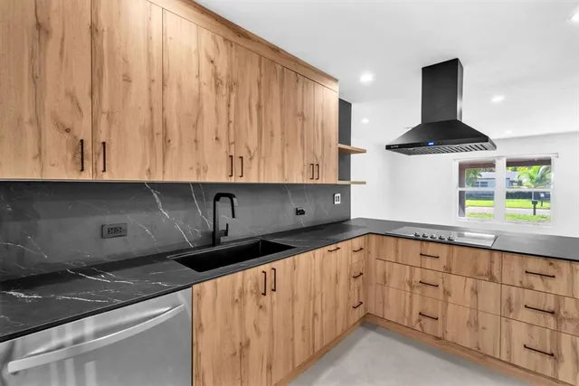 a kitchen with granite countertop a sink a stove and cabinets