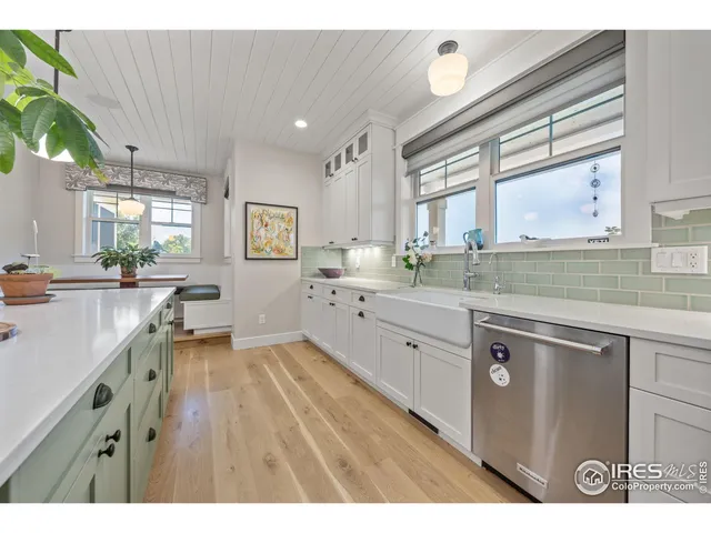 a kitchen with a sink appliances cabinets and a large window