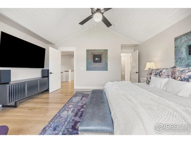 a spacious bedroom with a bed and a flat screen tv