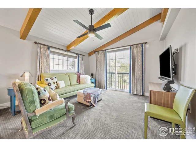 a living room with furniture a flat screen tv and a floor to ceiling window
