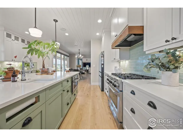 a large kitchen with stainless steel appliances kitchen island granite countertop a sink a counter space and a view of living room