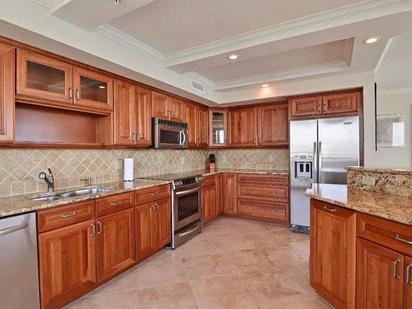 a kitchen with stainless steel appliances granite countertop wooden cabinets a stove top oven a sink and dishwasher