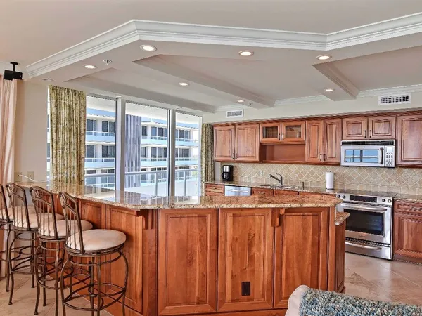 a kitchen with stainless steel appliances granite countertop a stove a sink and a refrigerator