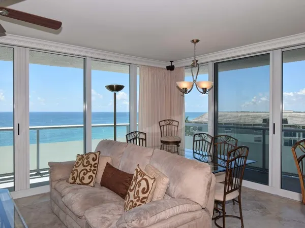 a living room with furniture a dining table and a chandelier