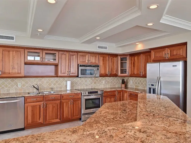 a kitchen with stainless steel appliances granite countertop a sink stove and refrigerator