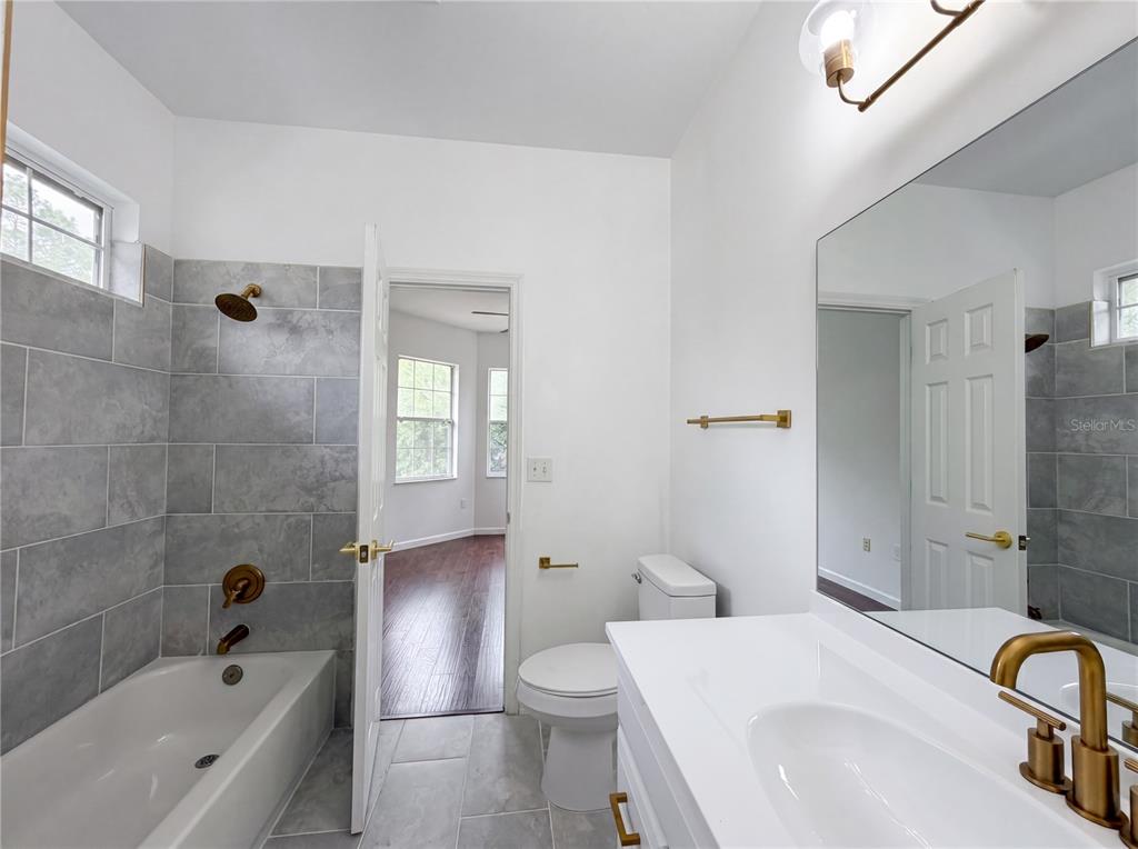 9405 Southwest 31st Lane Gainesville, FL 32608 - Photo 11 of 30 a bathroom with a sink a toilet and shower