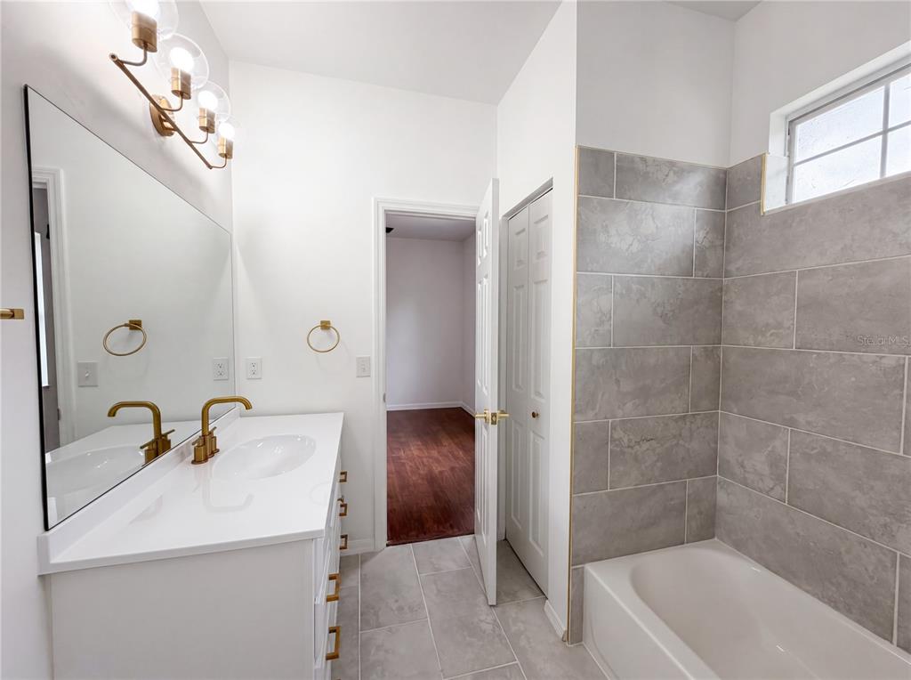 9405 Southwest 31st Lane Gainesville, FL 32608 - Photo 12 of 30 a bathroom with a tub a sink and mirror