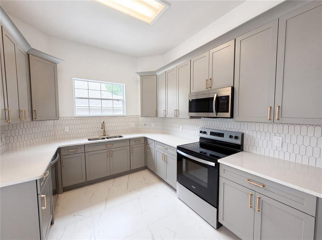 9405 Southwest 31st Lane Gainesville, FL 32608 - Photo 2 of 30 a kitchen with cabinets appliances a sink and a window
