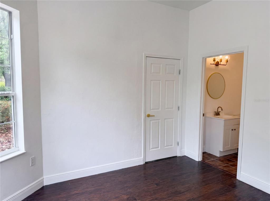 9405 Southwest 31st Lane Gainesville, FL 32608 - Photo 8 of 30 an empty room with wooden floor mirror and windows