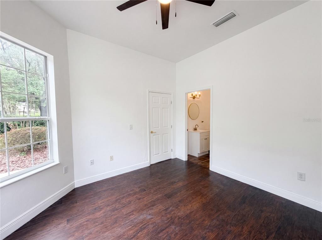 9405 Southwest 31st Lane Gainesville, FL 32608 - Photo 9 of 30 an empty room with wooden floor cabinet and windows