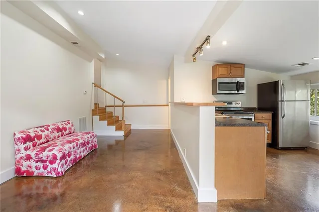 a kitchen with a table chairs refrigerator and microwave