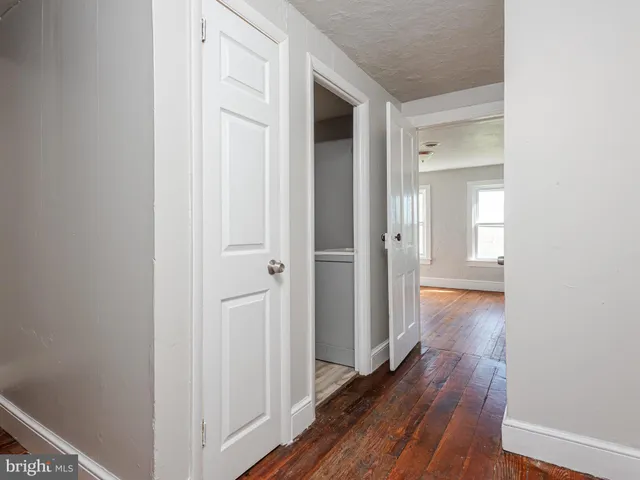 a view of a hallway with wooden floor