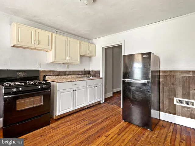 a kitchen with a refrigerator stove and wooden cabinets