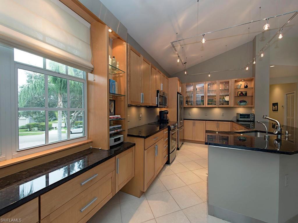 7120 Timberland Circle, Unit 202 Naples, FL 34109 - Photo 3 of 12 a kitchen with stainless steel appliances granite countertop a sink and a refrigerator