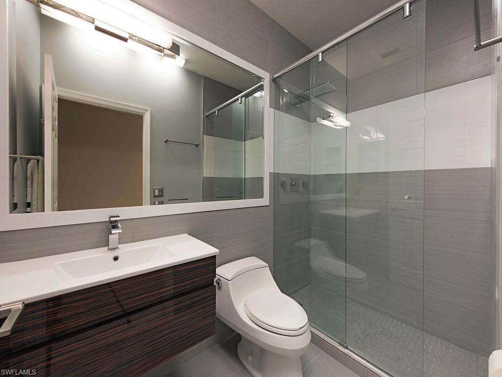 7120 Timberland Circle, Unit 202 Naples, FL 34109 - Photo 9 of 12 a bathroom with a sink mirror toilet and shower