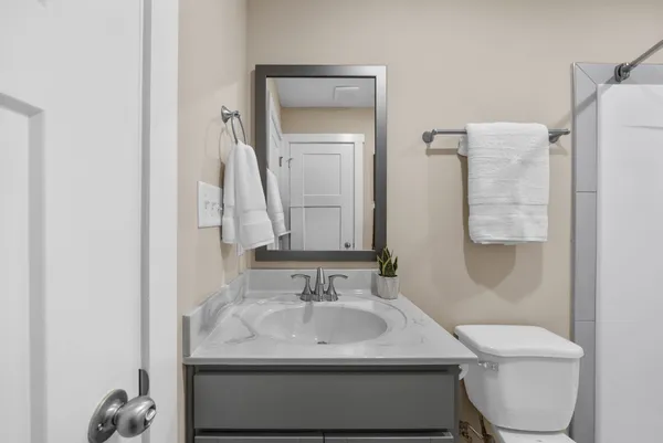 a bathroom with a sink toilet and mirror