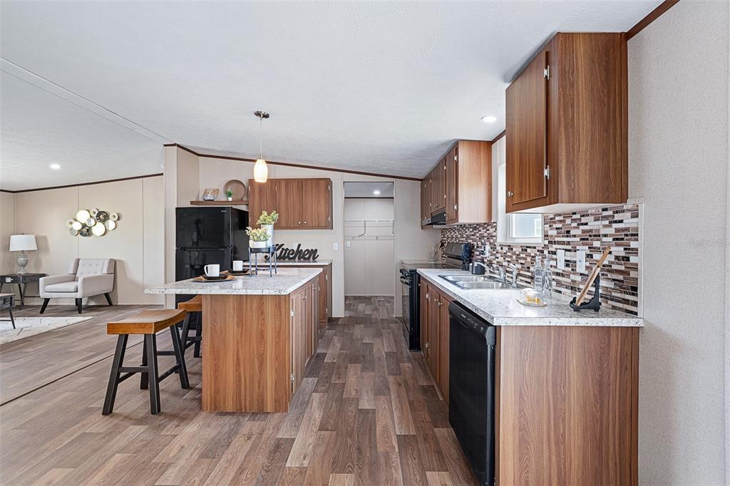 8150 Cherokee Road Bartow, FL 33830 - Photo 13 of 35 a kitchen with stainless steel appliances kitchen island granite countertop a sink stove and wooden cabinets