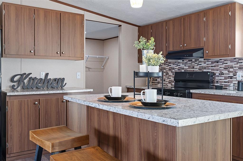 8150 Cherokee Road Bartow, FL 33830 - Photo 15 of 35 a kitchen with granite countertop a sink dishwasher stove and cabinets