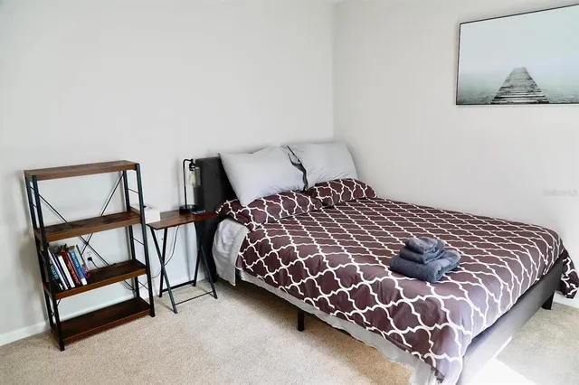 a bedroom with a bed and painting on the wall