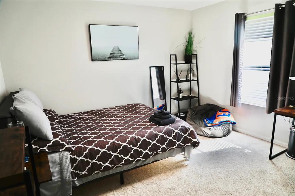 5164 Southwest 82 Terrace Gainesville, FL 32608 - Photo 18 of 25 a bedroom with bed and a painting on the wall