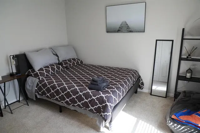 a bedroom with a bed and painting on the wall