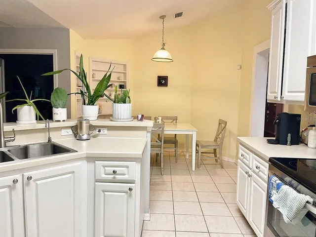 a kitchen with a sink and chairs