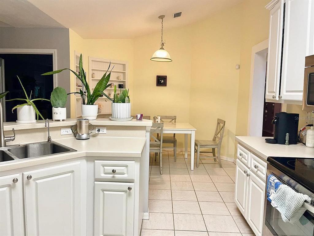 5164 Southwest 82 Terrace Gainesville, FL 32608 - Photo 21 of 25 a kitchen with a sink and chairs