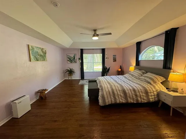 a bedroom with a bed lamps and wooden floor