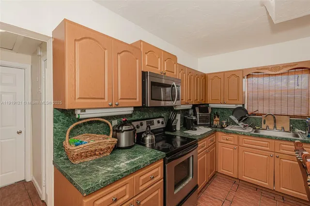 a kitchen with stainless steel appliances granite countertop a stove sink and cabinets
