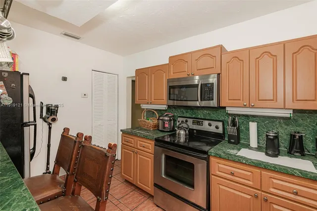 a kitchen with stainless steel appliances granite countertop a stove a sink and a microwave