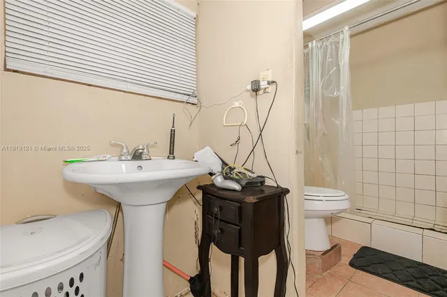 a view of a patio with table and chairs potted plants and floor to ceiling window