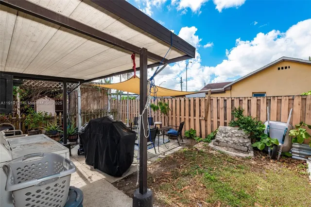 a view of a patio with a table and chairs under an umbrella