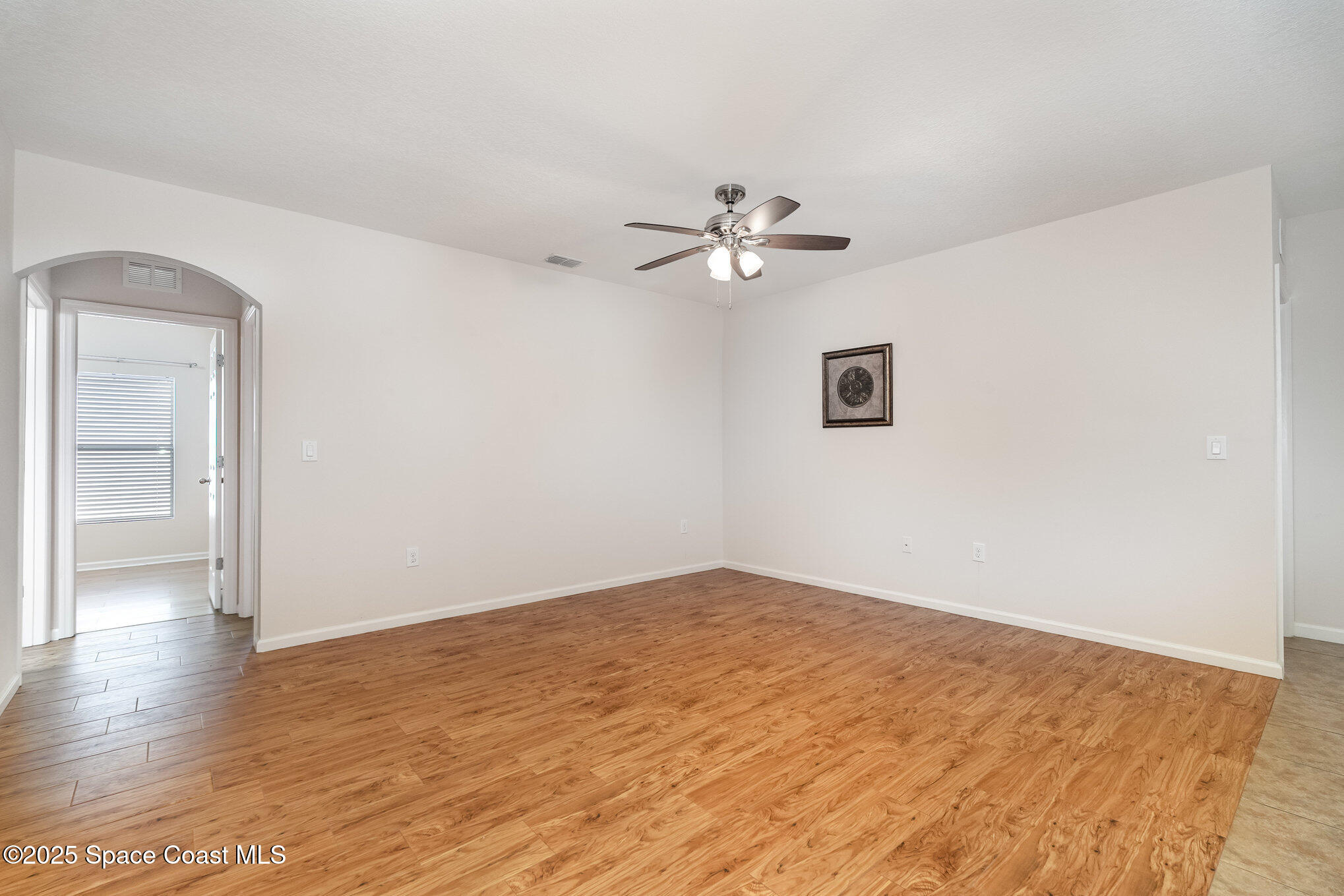 1517 Attilburgh Boulevard Melbourne, FL 32904 - Photo 2 of 15 an empty room with wooden floor and ceiling fan
