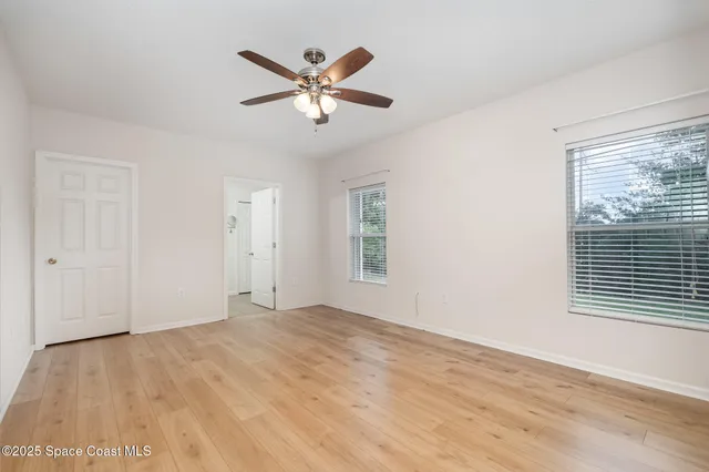 a view of a big room with wooden floor and windows