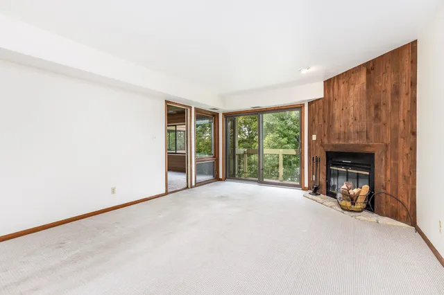 a view of an empty room with a fireplace and a window
