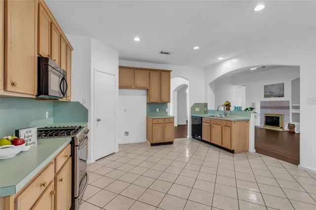 a kitchen with stainless steel appliances a stove a sink a microwave and cabinets