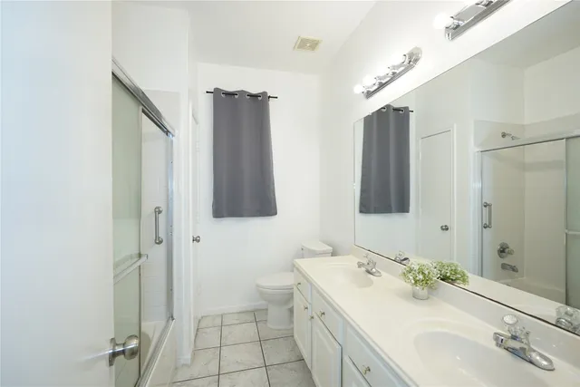 a bathroom with a double vanity sink mirror and shower