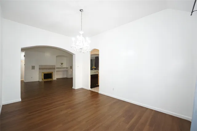 a view of a room with wooden floor fireplace and window