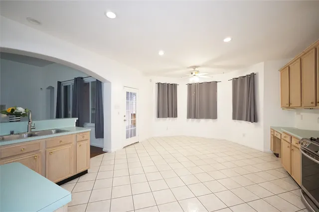 a large white room with a large window and kitchen view