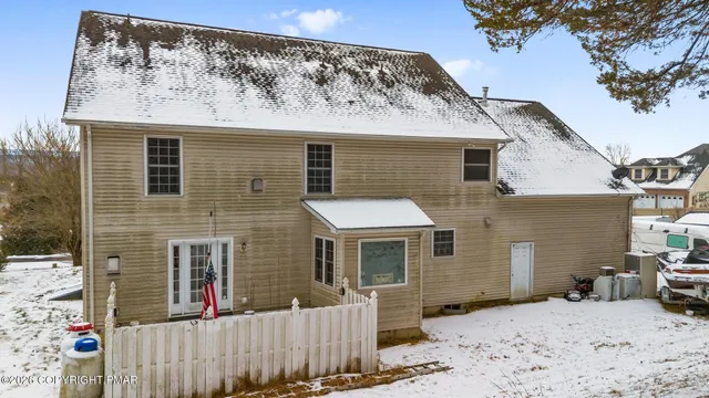 a view of a house with a wooden fence