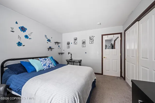 a bedroom with a bed and painting on the wall