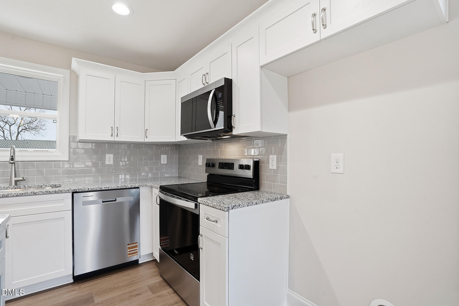 214 Rae Street Warsaw, NC 28398 - Photo 12 of 28 a kitchen with granite countertop white cabinets sink and stainless steel appliances