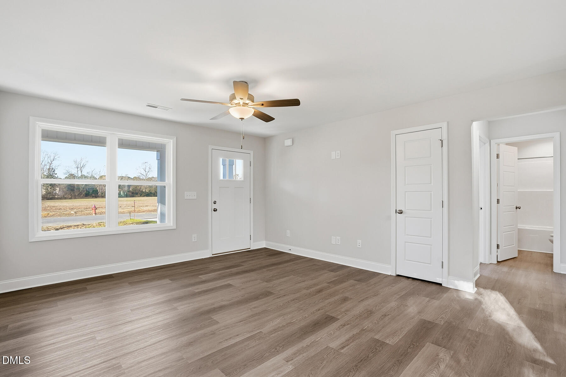 214 Rae Street Warsaw, NC 28398 - Photo 7 of 28 a view of an empty room with a window and wooden floor